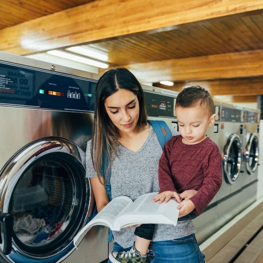 mom and son reading together in laundromat